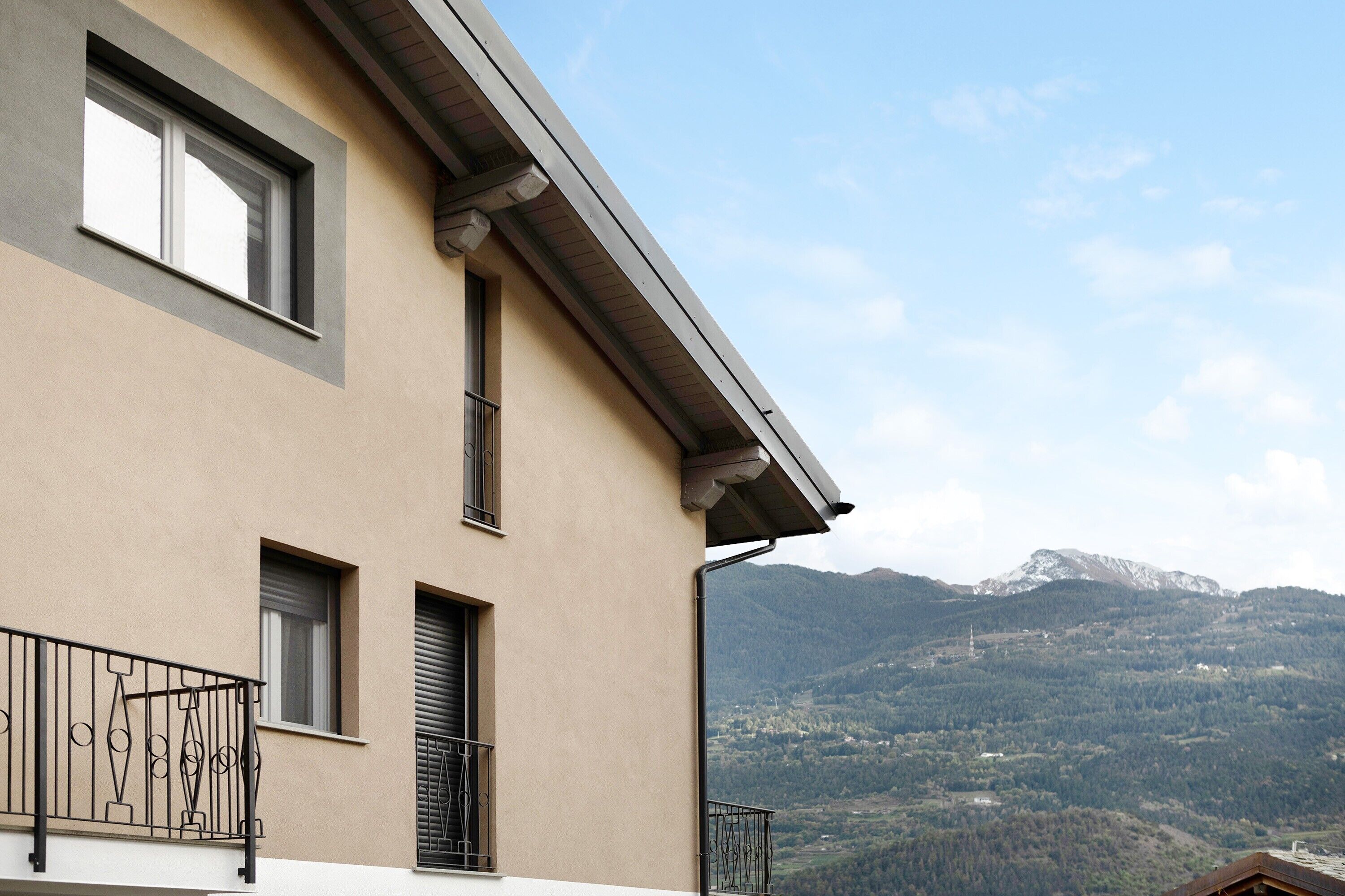 A building with a balcony, a window, and a mountain view.