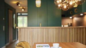 A wooden table with a white cup and a menu, a yellow chair, and a wooden partition in a restaurant setting.