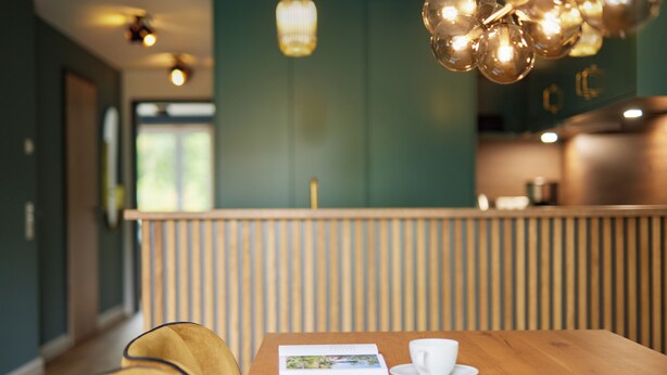 Una mesa de madera con una taza blanca y un menú, una silla amarilla y una partición de madera en un restaurante.
