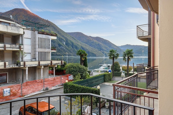 Un immeuble résidentiel doté de balcons donnant sur un lac et des montagnes.