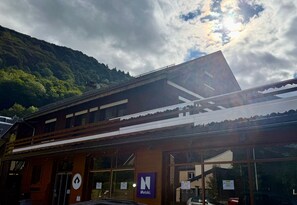 A building with a traditional architectural style, featuring a sloped roof and wooden beams. There is a sign with the letter 'N' and the word 'Netzk' visible on the facade.