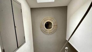 A staircase with a skylight, a decorative wall piece, and a door. - ✯ RENOVATED ✯ Charming studio Palais des Papes (Avignon)