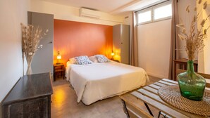 A bedroom with a bed, bedside lamps, a dresser, and a vase with dried plants. - ✯ RENOVATED ✯ Charming studio Palais des Papes (Avignon)