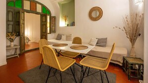 A dining area with a table, chairs, and a sofa.