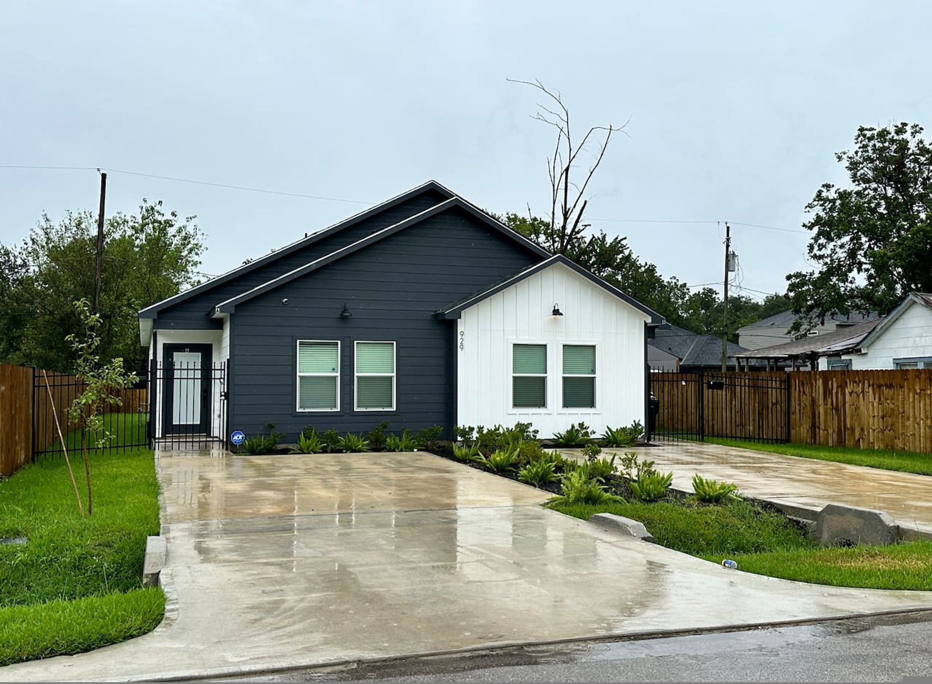 A two-story house with a dark exterior and a white front section.