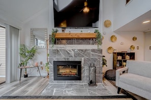 Una sala de estar moderna con chimenea, un televisor de pantalla plana montado arriba y una zona de estar acogedora.