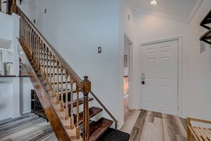 Un escalier avec des balustrades en bois et une plateforme recouverte de moquette.