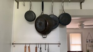 A kitchen with hanging pots and wooden utensils. - Quiet Heights Hideaway Walk to Restaurants (Houston)