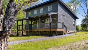 A modern two-story house with a covered porch and a garage. - Mountain Cabin Getaway Jacuzzi Stunning Views (Sevierville)