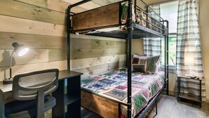 A bunk bed with a desk and chair, a lamp, and a window with curtains. - Mountain Cabin Getaway Jacuzzi Stunning Views (Sevierville)