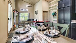 A dining area with a wooden table set for a meal, a pool table in the background, and a dark wooden cabinet to the right. - Mountain Cabin Getaway Jacuzzi Stunning Views (Sevierville)