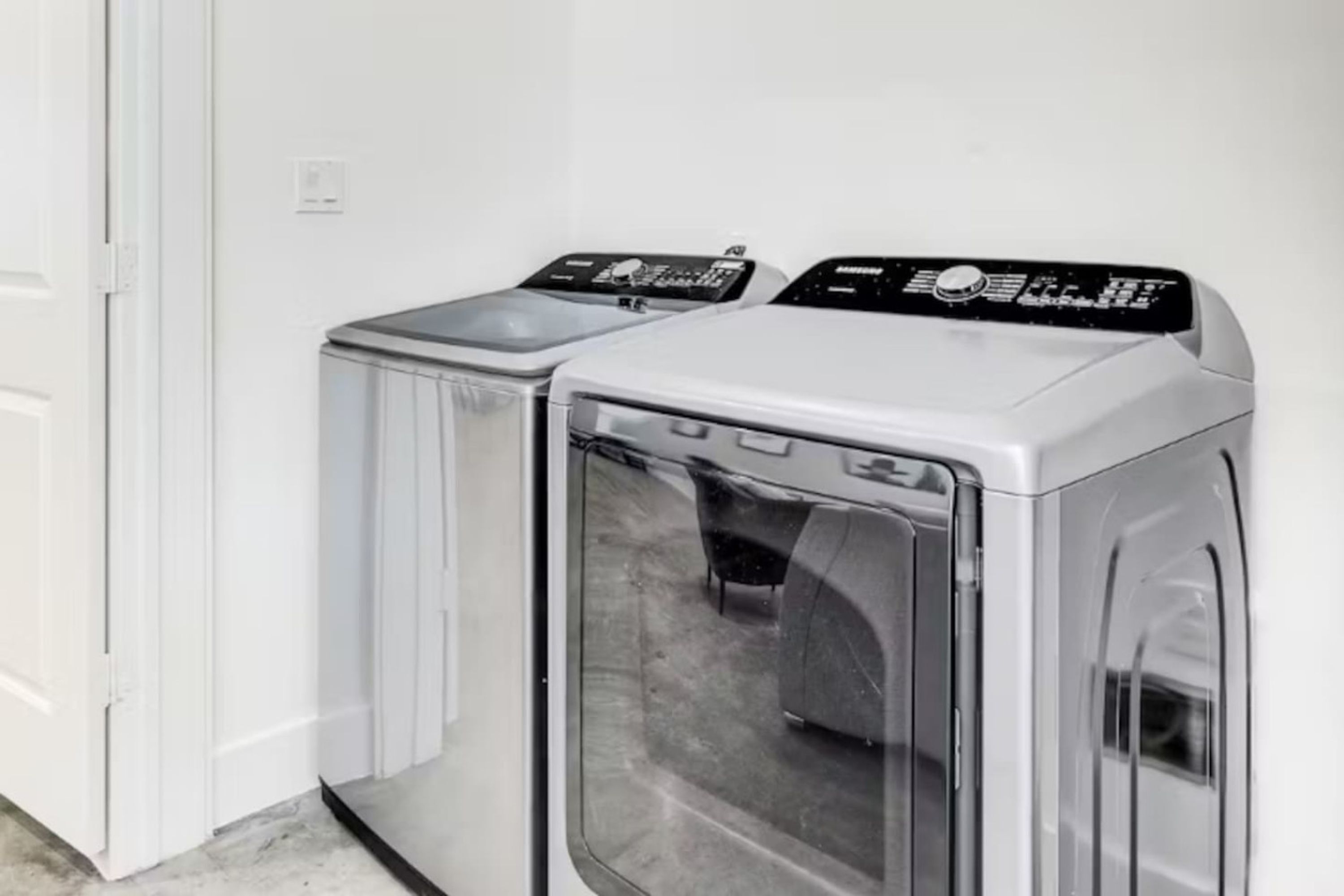 Une buanderie équipée de deux machines à laver à chargement frontal et d’un sèche-linge.