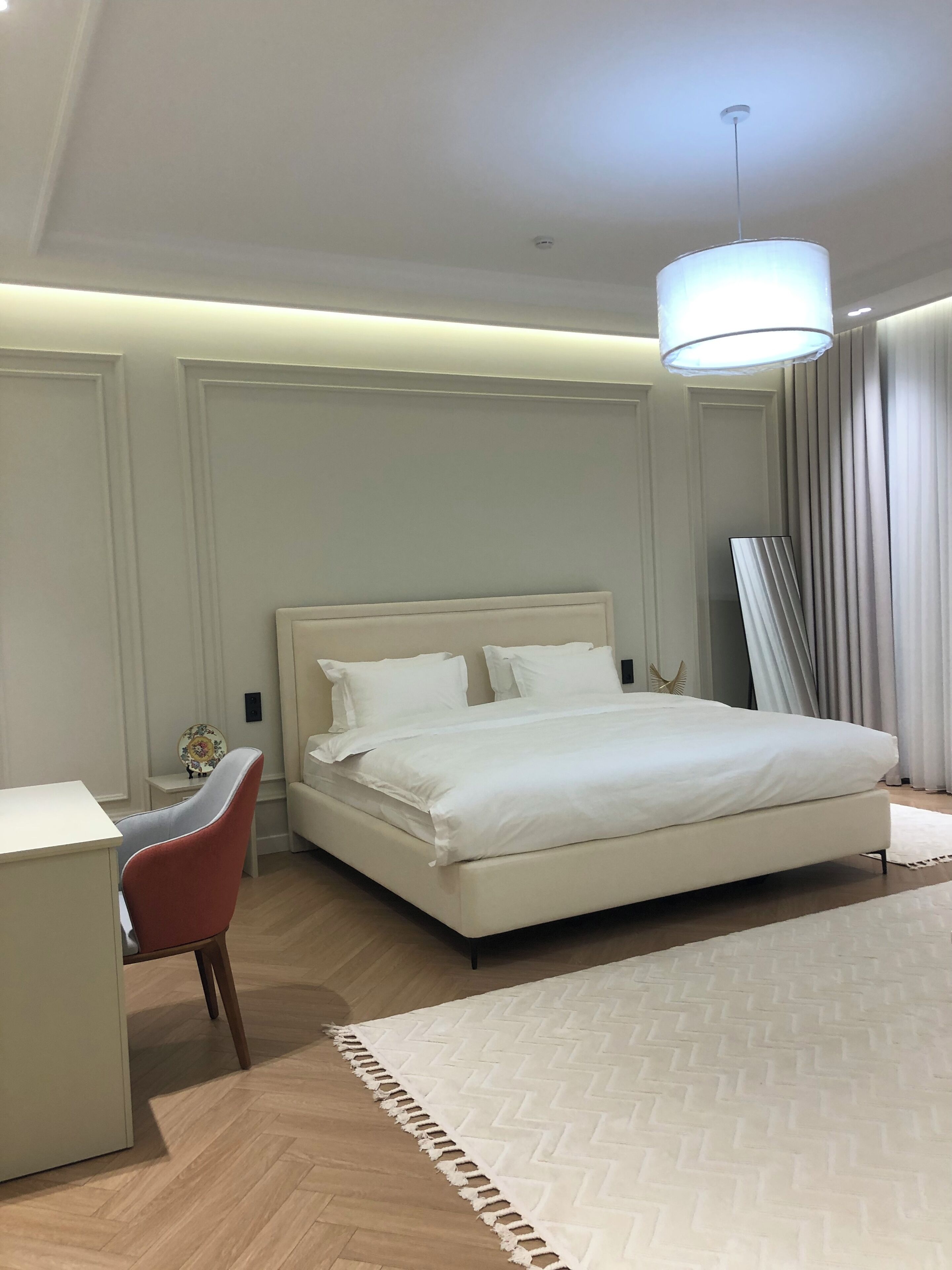 Ein modernes Schlafzimmer mit einem großen Bett, einem Schreibtisch und einem Stuhl.