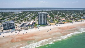 An aerial view of a coastal area with a beach, a large hotel with multiple floors, and a marina. - Roomy Oceanfront 2/2 condo with Million Dollar views in fabulous Daytona Beach!! (Daytona Beach)