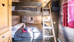 A bunk bed room with a ladder, wooden walls, a small window, and a wardrobe. - Apartment 'Chalet Refuge Loup Blanc Valfréjus' with Mountain View, Balcony and Wi-Fi (Valfréjus)