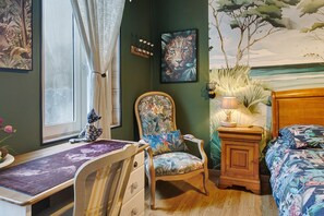 Una habitación con una cama, una silla, un escritorio y una lámpara.
