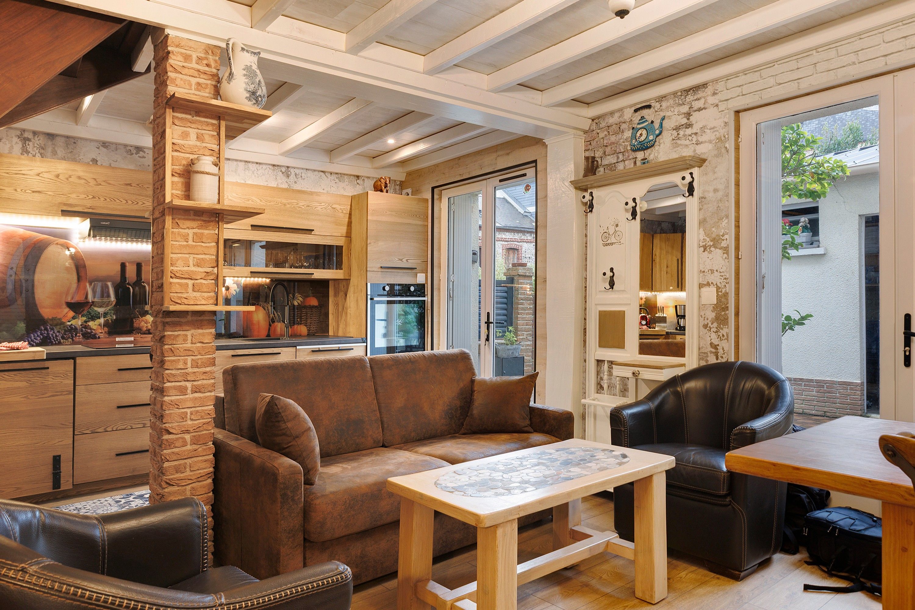 A cozy living area with a brown leather sofa, a wooden coffee table, and a leather armchair.