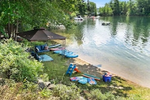 Un espace de camping au bord du lac, dotĂ© dâun espace de repos couvert, de kayaks et de planches Ă pagaie.