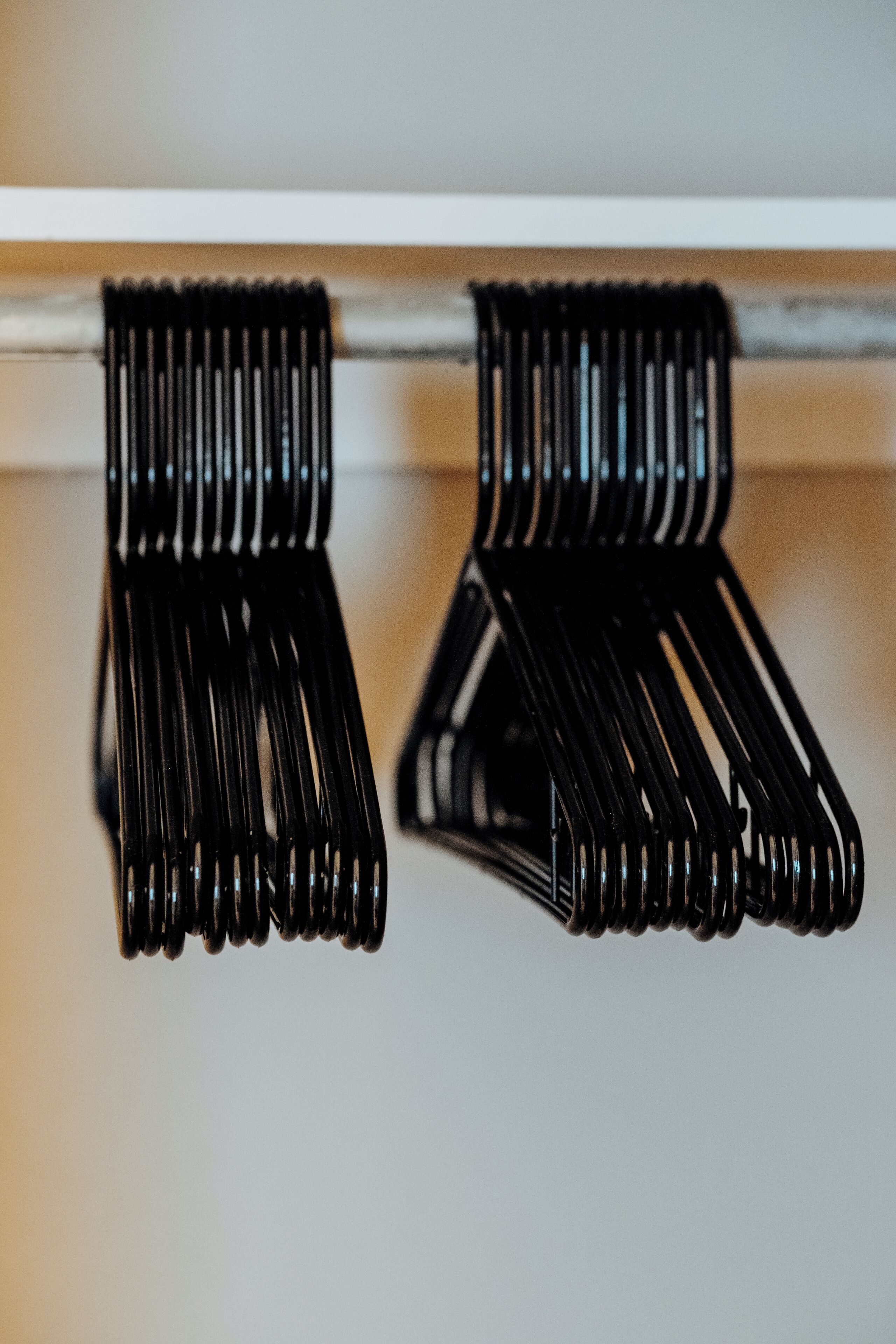 A pair of black metal hooks on a white wall.