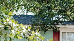 A two-story house with a green exterior, white doors, and red shutters. - Convenient 2BR Escape | Easy Walk to MOB (Mobile)