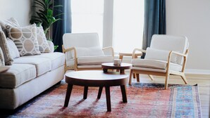 A living room with a sofa, two armchairs, a coffee table, and a patterned rug. - Convenient 2BR Escape | Easy Walk to MOB (Mobile)