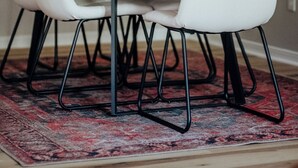 A dining area with a wooden table, white chairs, and a patterned rug. - Convenient 2BR Escape | Easy Walk to MOB (Mobile)