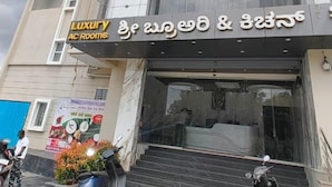 A multi-story building with a sign for "Luxury AC Rooms". - Sree Brewery and kitchen (Anekal)