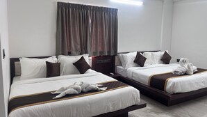A hotel room with two beds, each with white bedding and brown accents, a large window with curtains, and a flat-screen TV on a wooden stand. - Sree Brewery and kitchen (Anekal)
