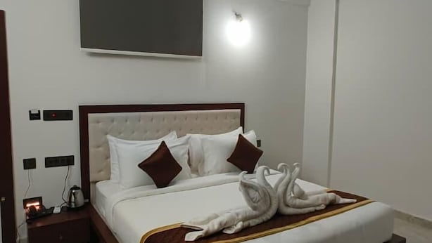 A modern hotel room with a large bed, a flat-screen TV, and a marble floor. - Sree Brewery and kitchen (Anekal)