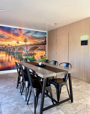 A conference room with a large table, chairs, and a mural of a sunset over a bridge. - Endless Summer, Pool/Theatre/Boat Parking/Walk to London Bridge! (Lake Havasu City)
