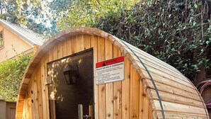 A wooden sauna with a door and a warning sign about overheating. - Church St Collection - Suite 16 (Fairhope)
