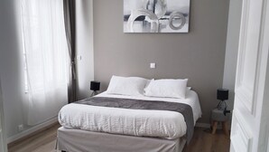 Une chambre à coucher avec un lit, une table de chevet, une lampe et un tableau au mur.