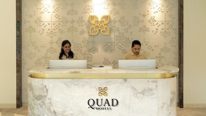 A reception desk at QUAD HOTELS with two employees at their computers. - Quad Hotels Hyderabad (Hyderabad)