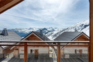A wooden chalet with a view of snow-covered mountains.
