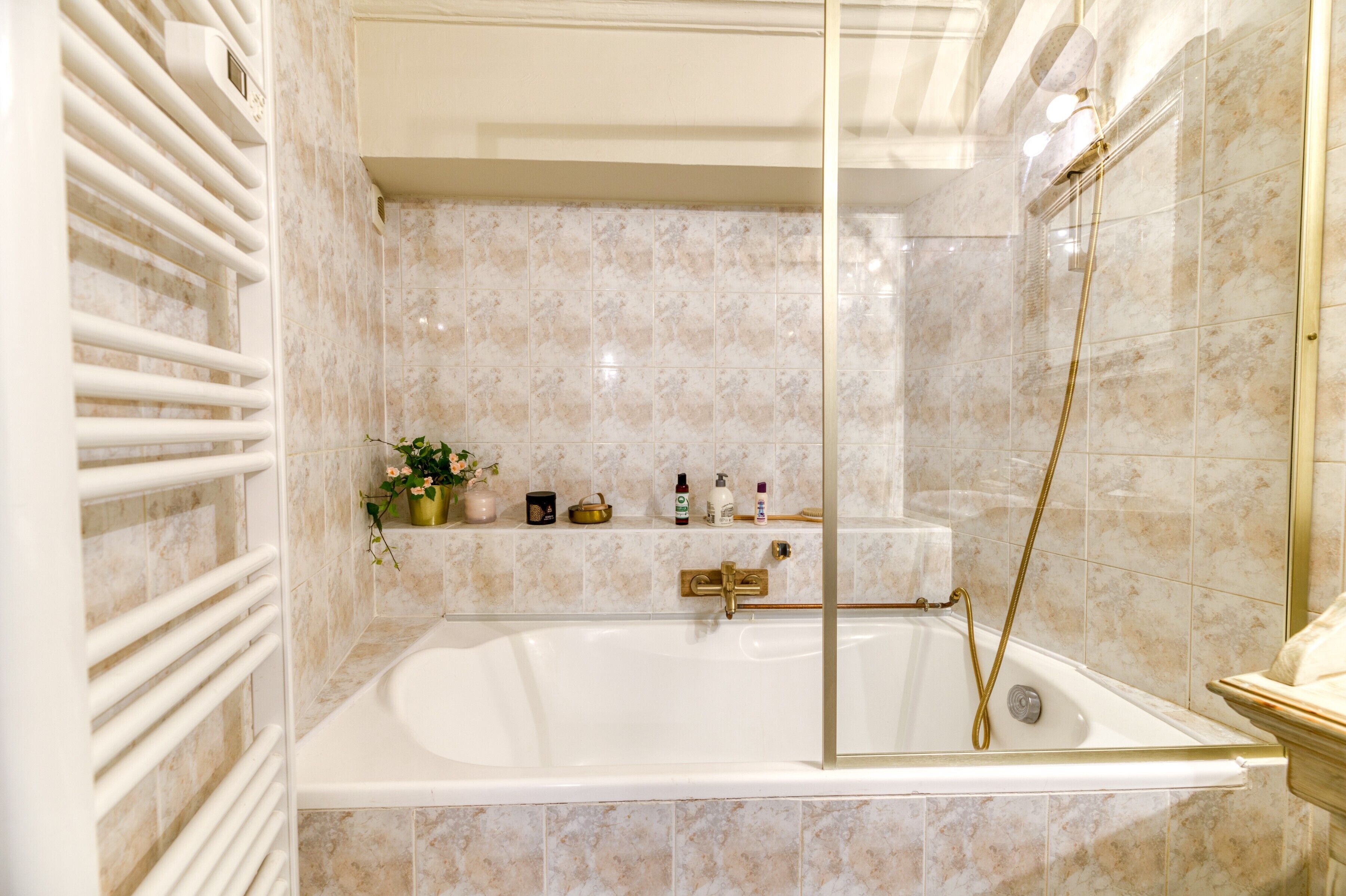 A modern bathroom with a freestanding bathtub, a glass-enclosed shower, and a white towel rack.