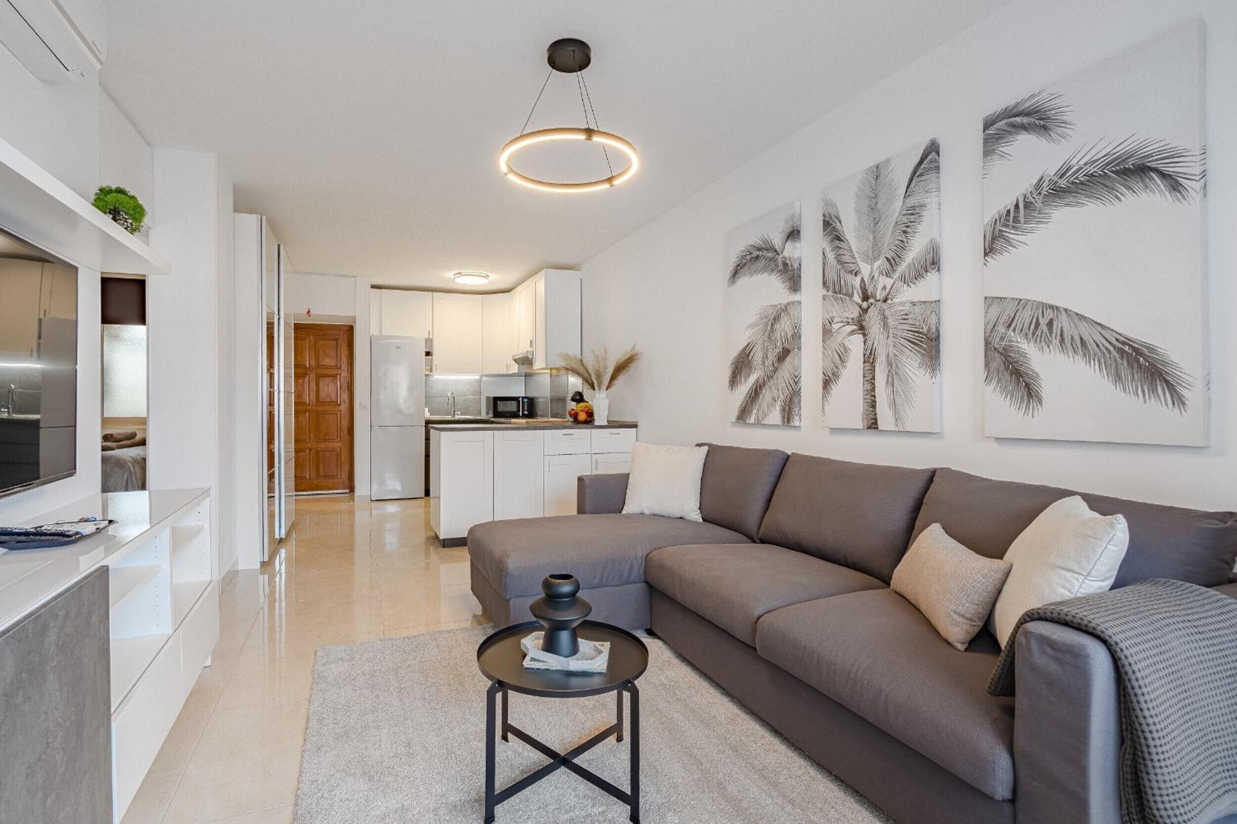 A modern living room with a sofa, coffee table, and artwork.
