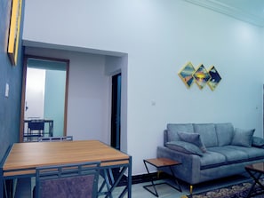 Deluxe Room | Living area | 60-inch Smart TV with satellite channels - X Best Apartments (Abuja)