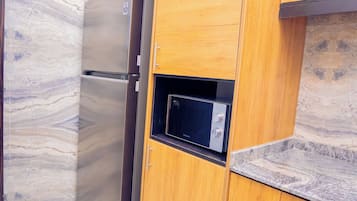 Deluxe Room | Private kitchen | Fridge, microwave, dining tables