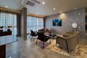 A modern living room with a sofa, chairs, a coffee table, and a rug. - Temporada Express (São Paulo)