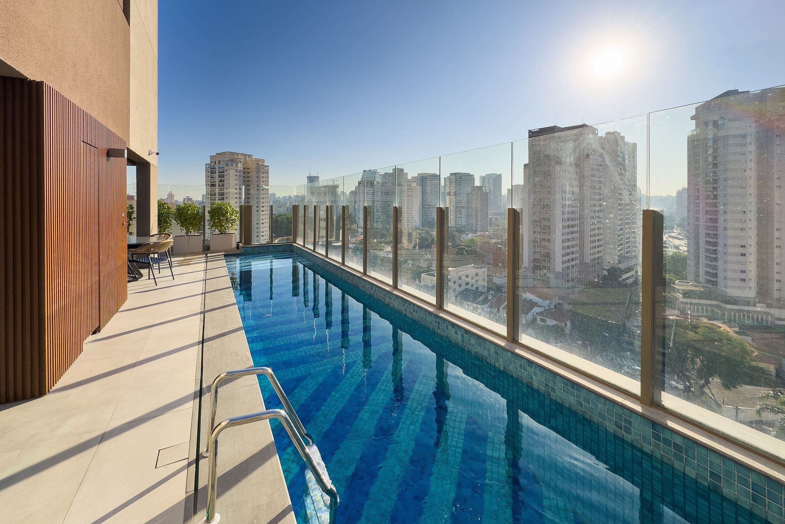 A rooftop pool with a city view, surrounded by high-rise buildings.