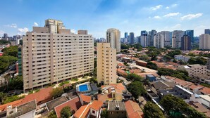 Un immeuble de grande hauteur, composé de nombreux étages, entouré de bâtiments résidentiels plus petits et d’espaces verts.