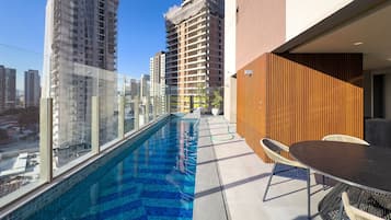 A rooftop pool with a view of surrounding high-rise buildings.