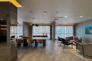 A spacious living area with a dining table, sofas, and a large window with curtains. - Temporada Express (São Paulo)