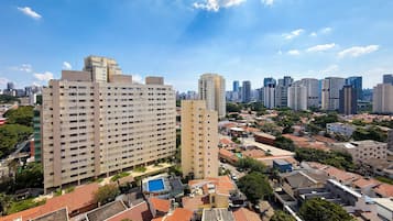 A high-rise building with multiple floors, surrounded by smaller residential buildings and greenery.