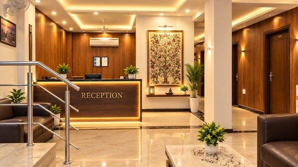 A reception area with a reception desk, a staircase, and a large wall-mounted artwork.