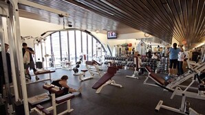 A gym with various exercise equipment, benches, and weights. - The Buckingham Athletic Club & Hotel (Chicago)