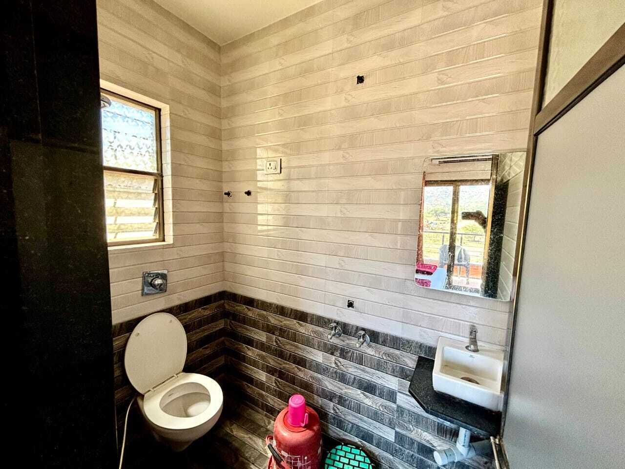 A compact bathroom with a toilet, sink, and a mirror.