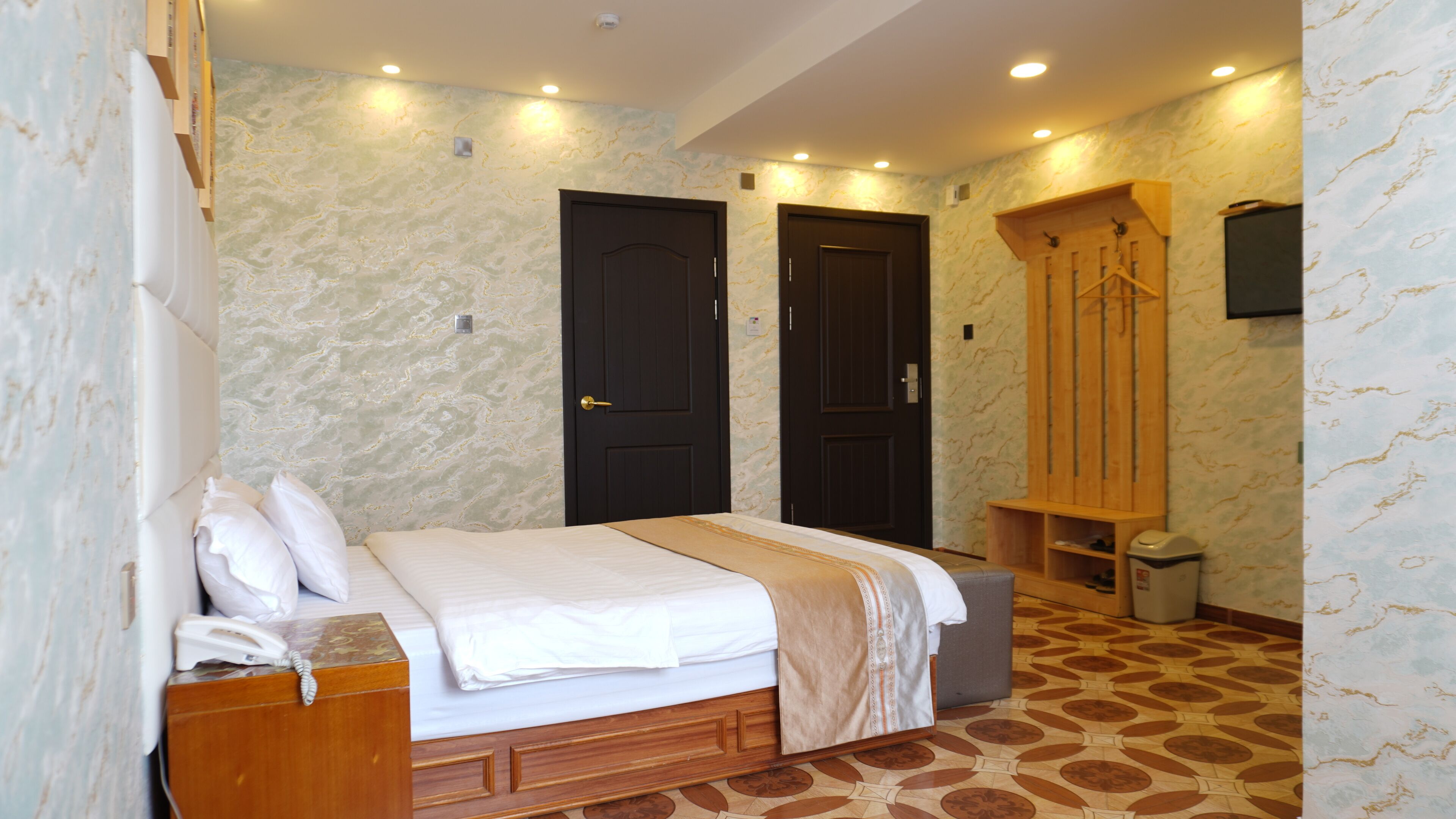 A bedroom with a bed, two doors, a wardrobe, and a bathroom.