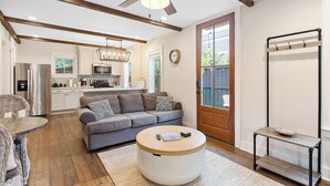 A modern living room with a round coffee table, a sofa, and a dining area. - 2bd Home, Large Private Backyard + Blocks to King! (Charleston)
