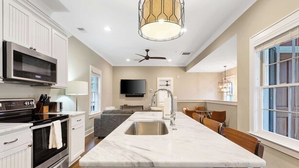 A modern kitchen with a central island, stainless steel appliances, and a large window.